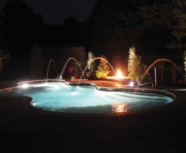 Illuminated backyard swimming pool beneath a Florida evening sky